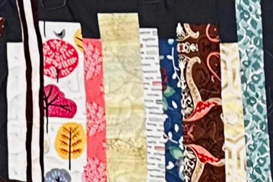 Fabric pieced together to look like books on a bookshelf.