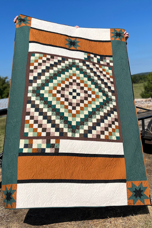 A colorful quilt with beautifully added borders in various fabrics.