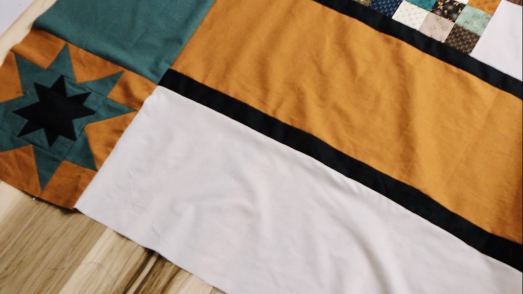 Borders cut, sewn, and pressed to add length to a quilt.